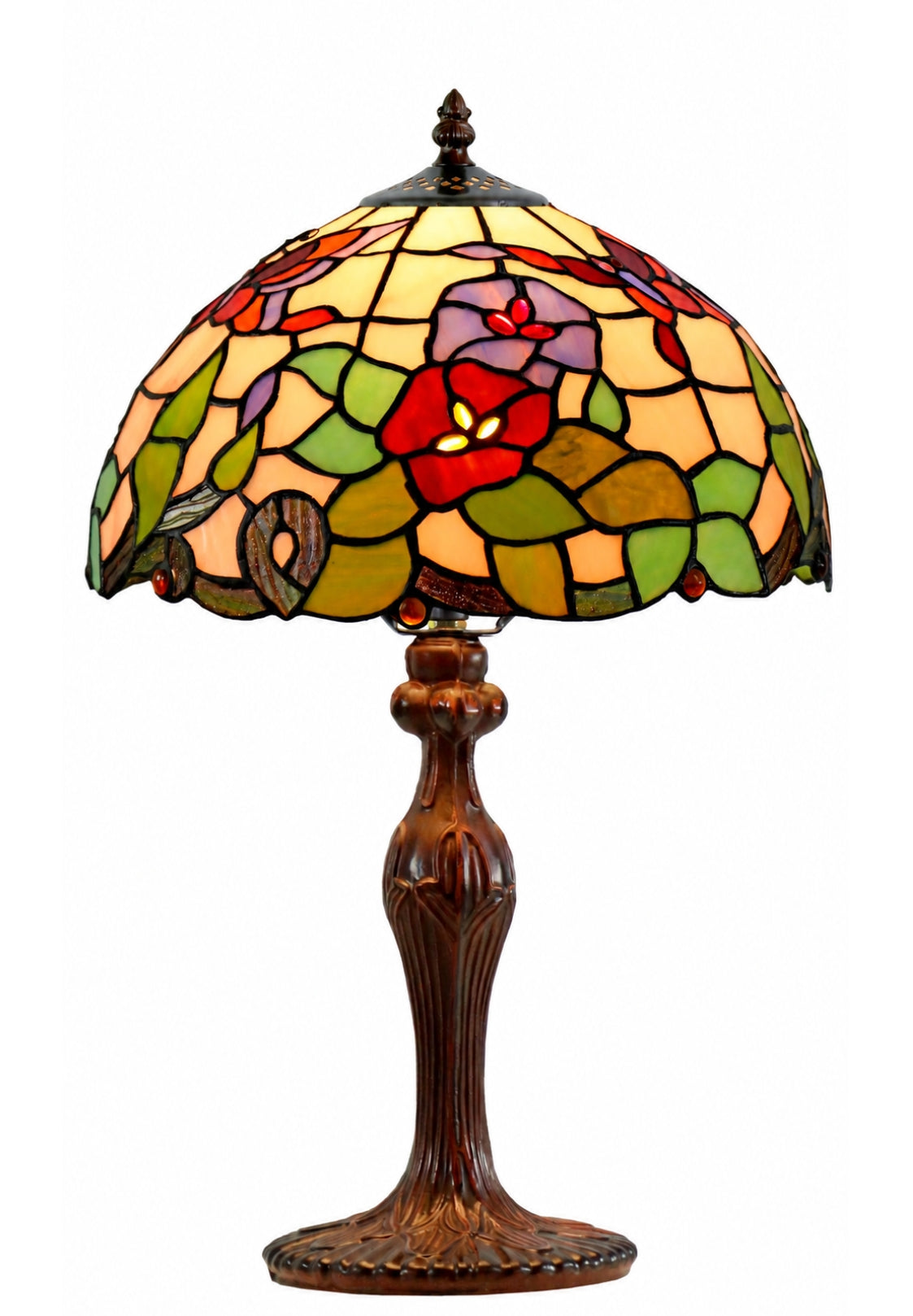 A Tiffany-style stained glass table lamp with a multicolor floral pattern on a warm yellow glass shade, supported by a dark brown carved wooden base, isolated on a white background.